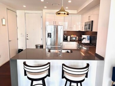 Kitchen featuring a sink, white cabinetry, a peni