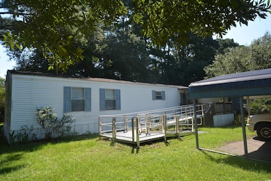 View of front facade featuring a wooden deck and a front lawn