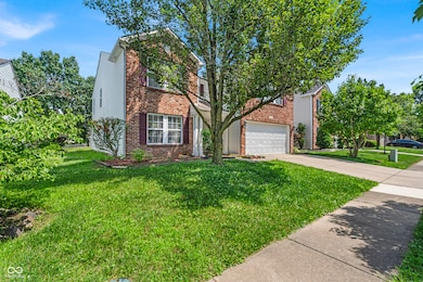 view of front of house with brick siding, concrete driveway, a front lawn, and a garage