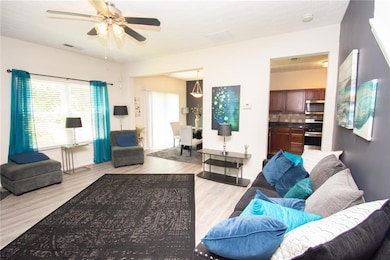 Living room with light wood-style flooring and a ceiling fan
