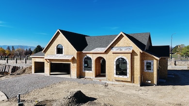 View of front of property featuring gravel driveway, an attached garage, roof with shingles, and brick siding