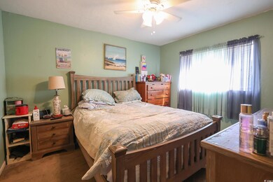 Bedroom featuring a ceiling fan and carpet