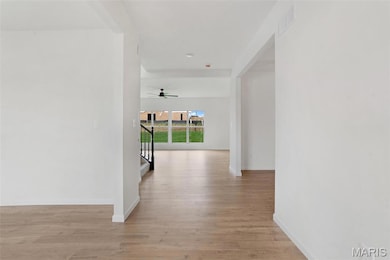 Hallway with light wood-style flooring and stairway