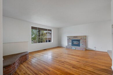 Unfurnished living room featuring light wood-style flooring and a stone fireplace