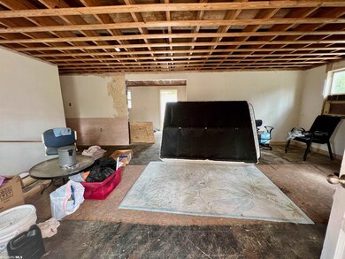 View of living room facing kitchen and rear door.