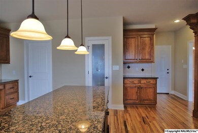 Large kitchen island with breakfast bar, tile back splash, and stainless steel appliances complete this kitchen.