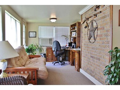 Photo. Sun room with exposed brick and office area
