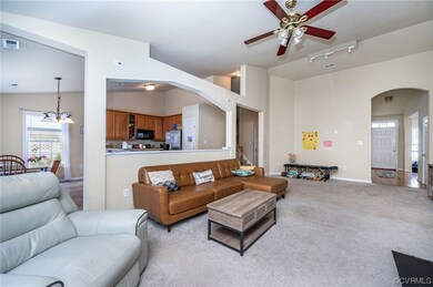 Den with view of kitchen, hallway and foyer.