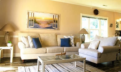 Living area featuring crown molding and wood finished floors