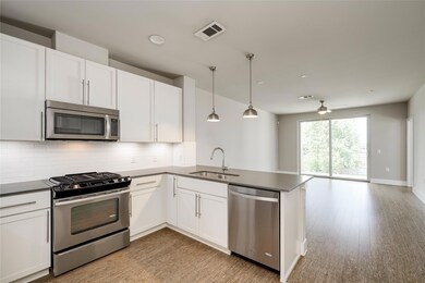 Kitchen with stainless steel appliances, a sink, ceiling fan, decorative backsplash, and open floor plan