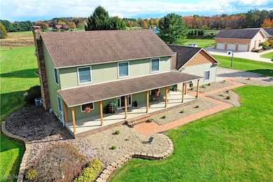 View of front of home with a front yard, roof with shingles, a porch, and a chimney