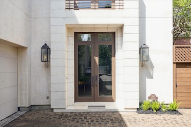Front door leading to foyer area with rich stone floors, high ceiling, elevator and elegant powder bath.