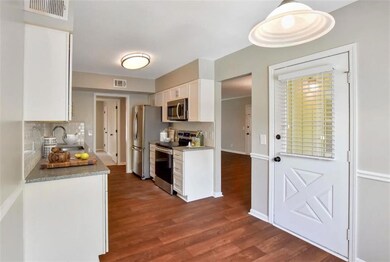 Kitchen with white cabinetry, tasteful backsplash,