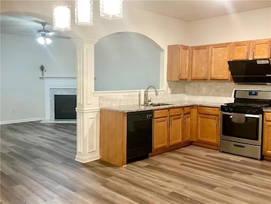 Kitchen featuring black dishwasher, gas stove, a sink, and light wood finished floors