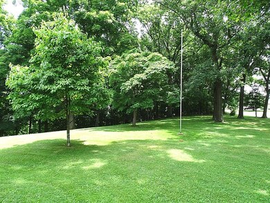 Level front yard with many mature trees