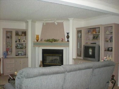 Another view of the living room with a fireplace with gas logs