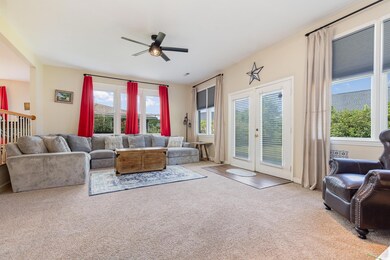 Living room featuring ceiling fan, light carpet, a