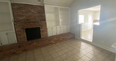 Unfurnished living room featuring a brick fireplac