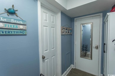 Hall featuring dark wood-style floors and baseboards