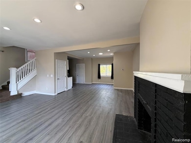 Unfurnished living room with recessed lighting, stairway, wood finished floors, and a fireplace