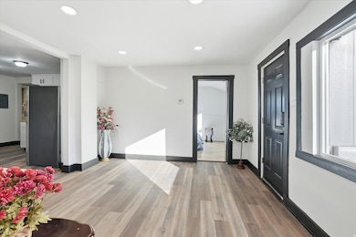 Entrance foyer with dark wood finished floors and recessed lighting