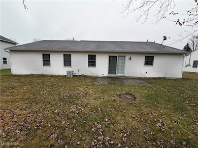 Back of property featuring a patio area, a yard, and a shingled roof