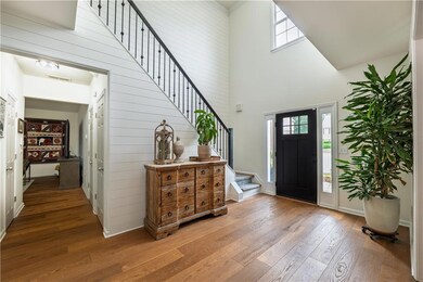Two story entryway featuring stairs and hardwood floors.