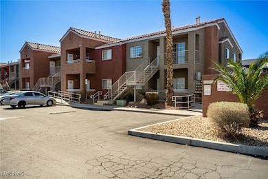 View of property with uncovered parking and stairs