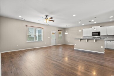 Kitchen with dark wood-style flooring, stainless s