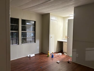 Empty room with dark wood-style floors and built in study area