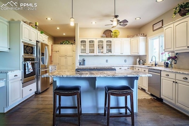 Kitchen with appliances with stainless steel finishes, a sink, a kitchen bar, a center island, and recessed lighting