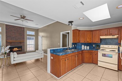 Kitchen with brick wall, light tile flooring, a sk