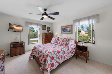 Carpeted bedroom featuring a ceiling fan