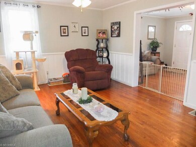 Formal living room with wood flooring, crown moldi