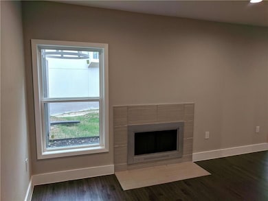 Unfurnished living room featuring baseboards, a f