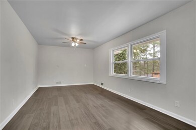 Spare room with baseboards, dark wood-style floors