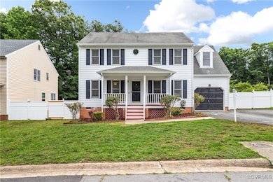 Colonial home featuring covered porch, a garage, d