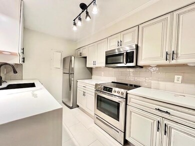 Kitchen featuring appliances with stainless steel finishes, decorative backsplash, and light countertops