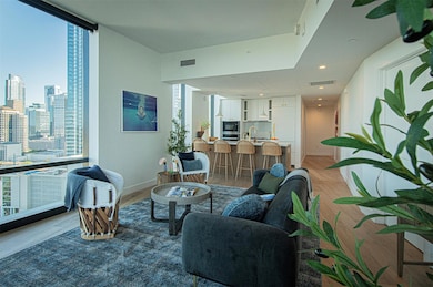Living area featuring visible vents, a wall of wi