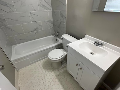 Bathroom with washtub / shower combination, vanity, and toilet