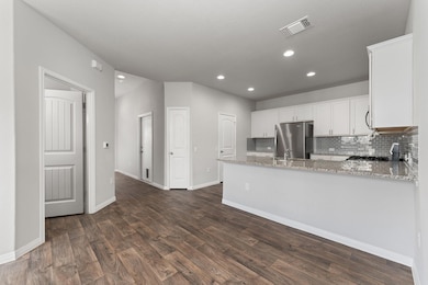 Kitchen featuring freestanding refrigerator, dark