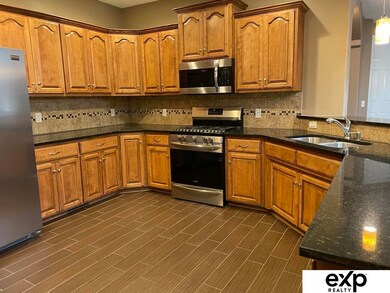 Granite counters with high top for eating, SS appliances & sink.