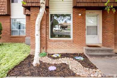 Entrance to property with central AC, mansard roof, and brick siding