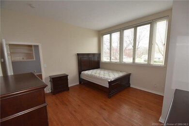 The bedroom features hardwood floor and large wind