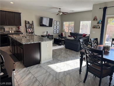 Kitchen featuring ceiling fan, dark stone countert