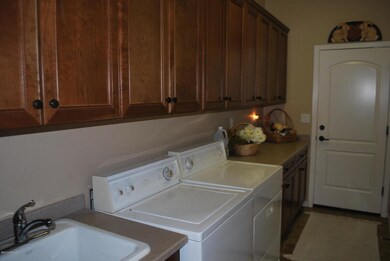 Laundry room w/ tub, cabinets & counter