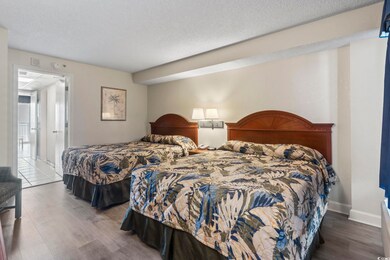 Bedroom with a textured ceiling and wood-type floo