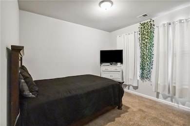 Bedroom with baseboards, visible vents, and light 