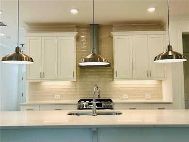 Kitchen featuring backsplash, wall chimney range h