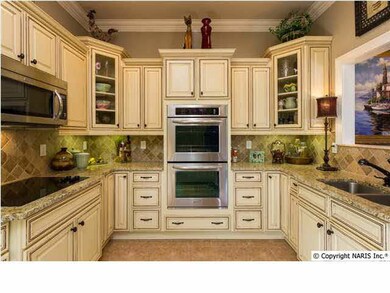 Efficient style meets inviting warmth in this beautiful kitchen featuring granite countertops, stainless steel appliances, hardwood floors and custom cabinetry.